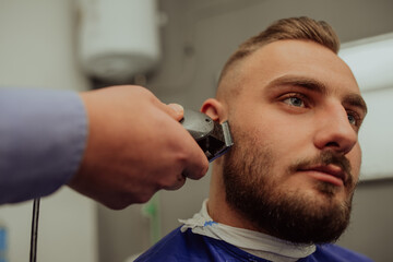 Fototapeta premium Young Man in Barbershop Hair Care Service Concept. Selective focus