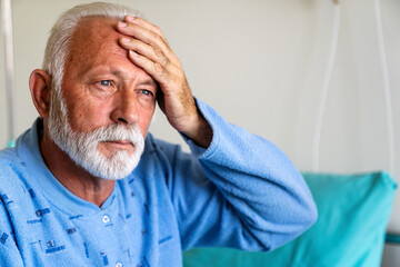 Senior male patient in hospital bed who is recovering from the disease. Healthcare concept.