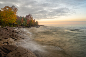 Dusk settles over Union Bay shoreline in autumn colors and Lake Superior, in the Porcupine Mountain Wilderness State Park, near Ontonogon, Michigan.