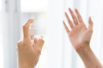 Cloes up woman wipes her hands with alcohol based handwashing spray as a preventive hygiene measure against coronavirus infection. Antibacterial hand female sanitizer gel. Soft focus