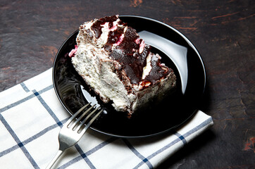 Plate with slice of tasty chocolate cake on table. Yummy dessert on on wooden background, closeup