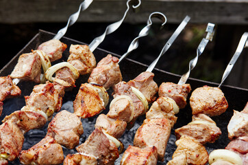 Marinated shashlik preparing on a barbecue grill over charcoal. Traditional Russian shashlik on a barbecue skewer