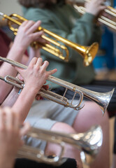 a small jazz band showing close ups of hands on brass instruments