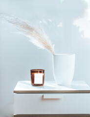 Scandinavian design with pampas grass and white vase and a candle, hygge feeling