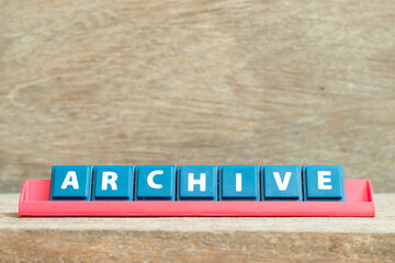 Tile alphabet letter with word archive in red color rack on wood background