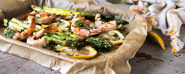 baking sheet with asparagus, shrimps, garlic and lemon on the table