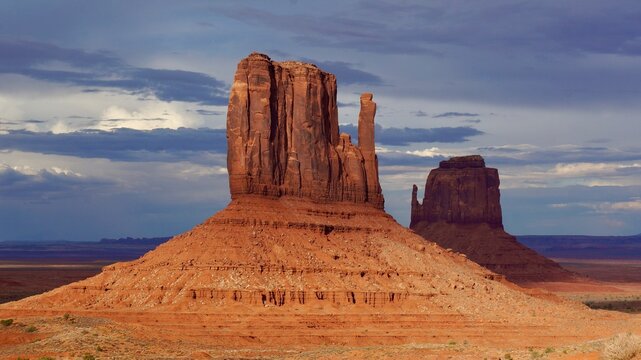 Monument Vally,Mitten and Merrick at sunset.
From left: West Mitten Butte and East Mitten Butte in the sunset.
There is a cloud over East Mitten in the back.