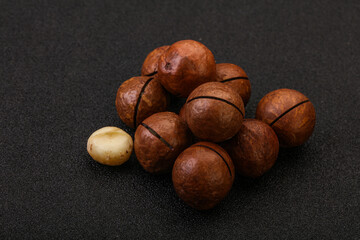 Brown macadamia nut heap over background
