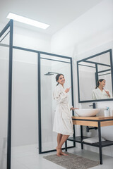 A picture of a young woman in a bathrobe in the bathroom