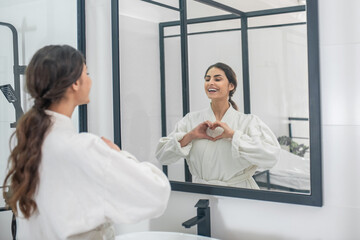 Fototapeta premium A picture of a young woman in a bathrobe in the bathroom