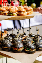 Close up of mini black fish burgers at catering event - obrazy, fototapety, plakaty
