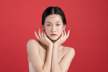 Beautiful young asian woman with clean fresh skin on red background, Face care, Facial treatment,...