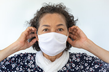 The portrait of an elderly woman wearing a protective mask