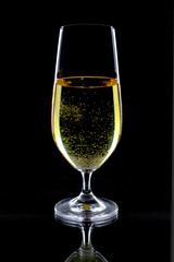 White wine in a glass, on a black background.