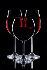 Red wine in a glass, on a black background.