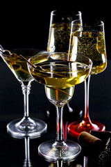 White wine in a glass, on a black background.