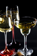 White wine in a glass, on a black background.