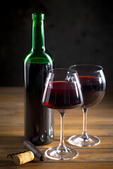 Wine in a glass, on an old background, with a bunch of grapes. Natural product.