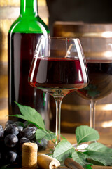 Wine in a glass, on an old background, with a bunch of grapes. Natural product.