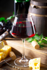 Wine in a glass, on an old background, with a bunch of grapes. Natural product.