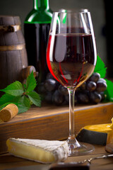 Wine in a glass, on an old background, with a bunch of grapes. Natural product.