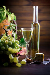 Wine glass with bottle and grapes on an old background.