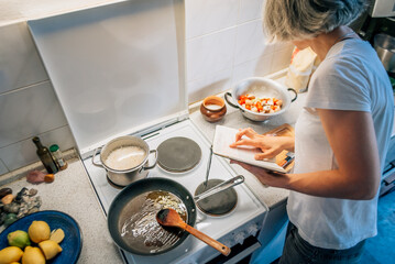 A woman checks products according to the recipe during cooking