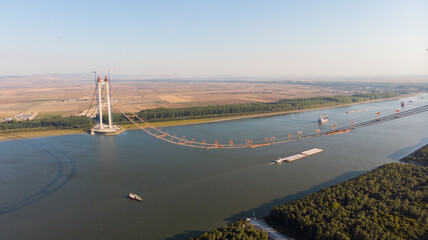 Panoramic aerial drone view from above of the suspended bridge over danube river, under...