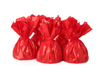 Delicious candies in red wrappers on white background