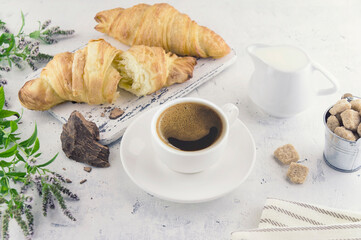 Cup of coffee with croissants, a slice of natural cocoa liquor, milk and cane organic unrefined...