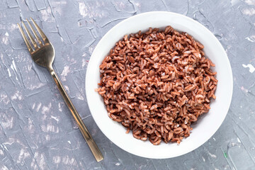 Rice red in bowl isolated on grey background. Asian food cooked.