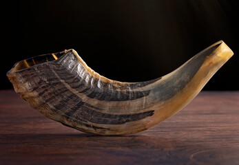 A Shofar Rams Horn on a Dark Wooden Table