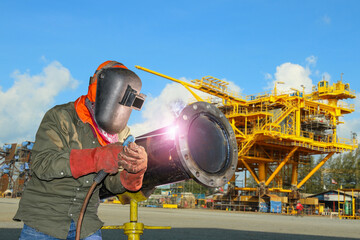 Welder is welding process on metal steel pipe in Oil drill rig yard for construction site