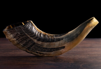 A Shofar Rams Horn on a Dark Wooden Table