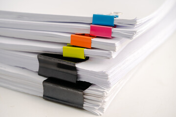 Stack of report paper files in business office clips.