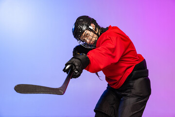 Cropped portrait of professional female hockey player training in special uniform with helmet...