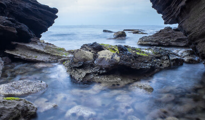 Fototapeta na wymiar beach of rocks and the coast of the ocean at the sunset