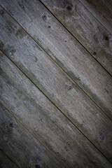 Wooden logs of an old house. Close-up. Weathered natural gray wood texture. Background. vertical photo.