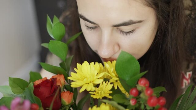 Woman Smelling the Bouquet of Flowers Closeup