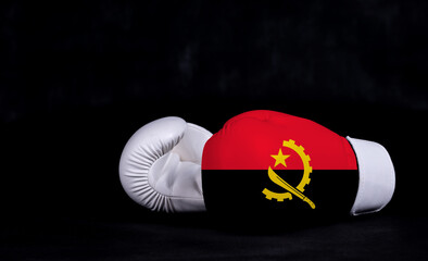Boxing glove with Angola flag on black background
