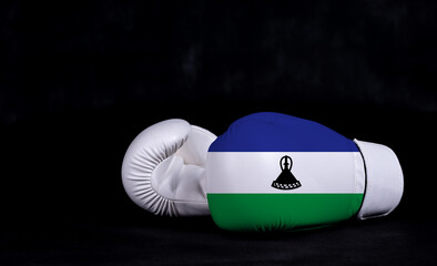 Boxing glove with Lesotho flag on black background