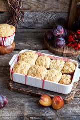 Plum cobbler on a wooden background.
