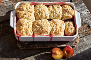 Plum cobbler on a wooden background.