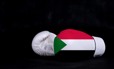 Boxing glove with Sudan flag on black background