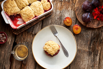 Plum cobbler on a wooden background.