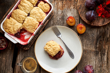 Plum cobbler on a wooden background.