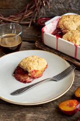 Plum cobbler on a wooden background.