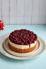Cherry cake. Breton shortcrust pastry. Cheesecake. Cherry sauce. Side view. Blue and white background.