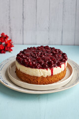 Cherry cake. Breton shortcrust pastry. Cheesecake. Cherry sauce. Side view. Blue and white background.