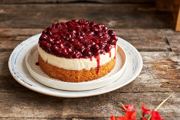 Cherry cake. Breton shortcrust pastry. Cheesecake. Cherry sauce. Side view. Wooden background.